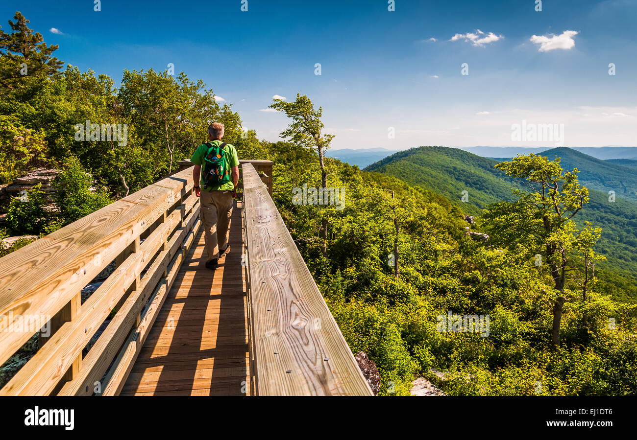 Hiker crossing a walking bridge on Big Schloss, in Washington