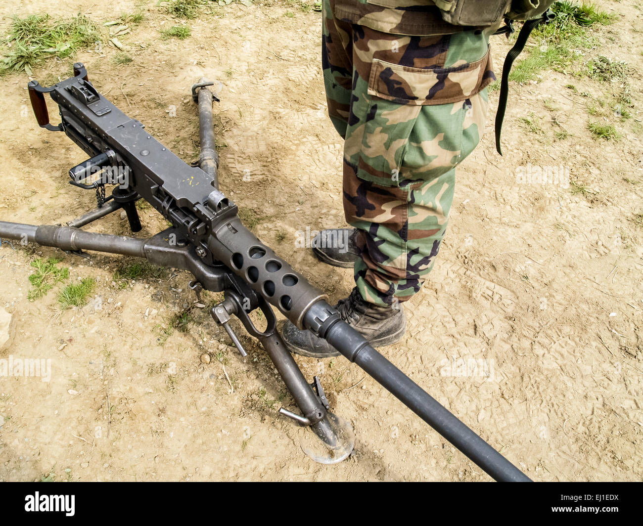 Machine gun on ground near legs of soldier wearing camouflage Stock ...