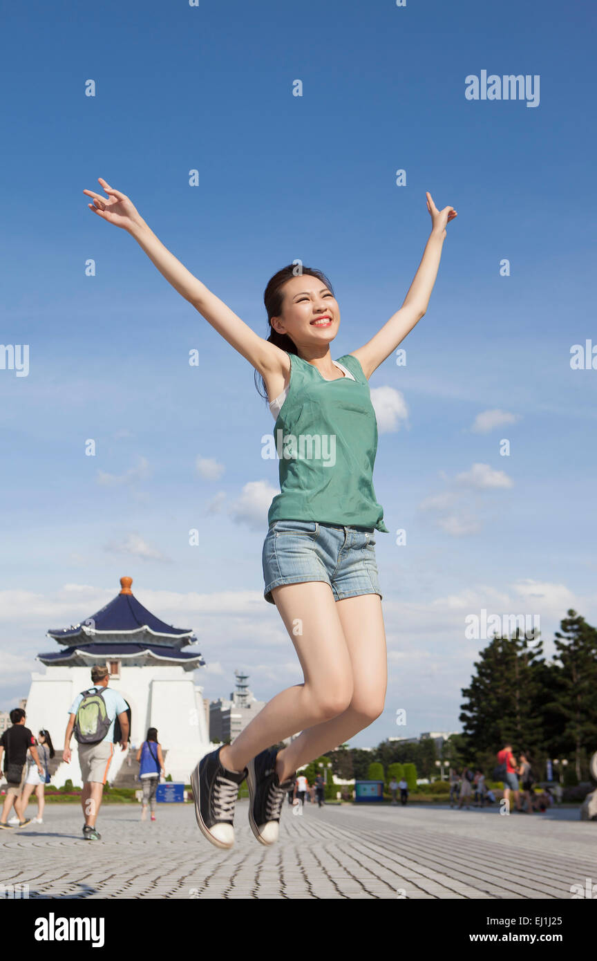 Young woman jumping in mid-air with smile, Stock Photo