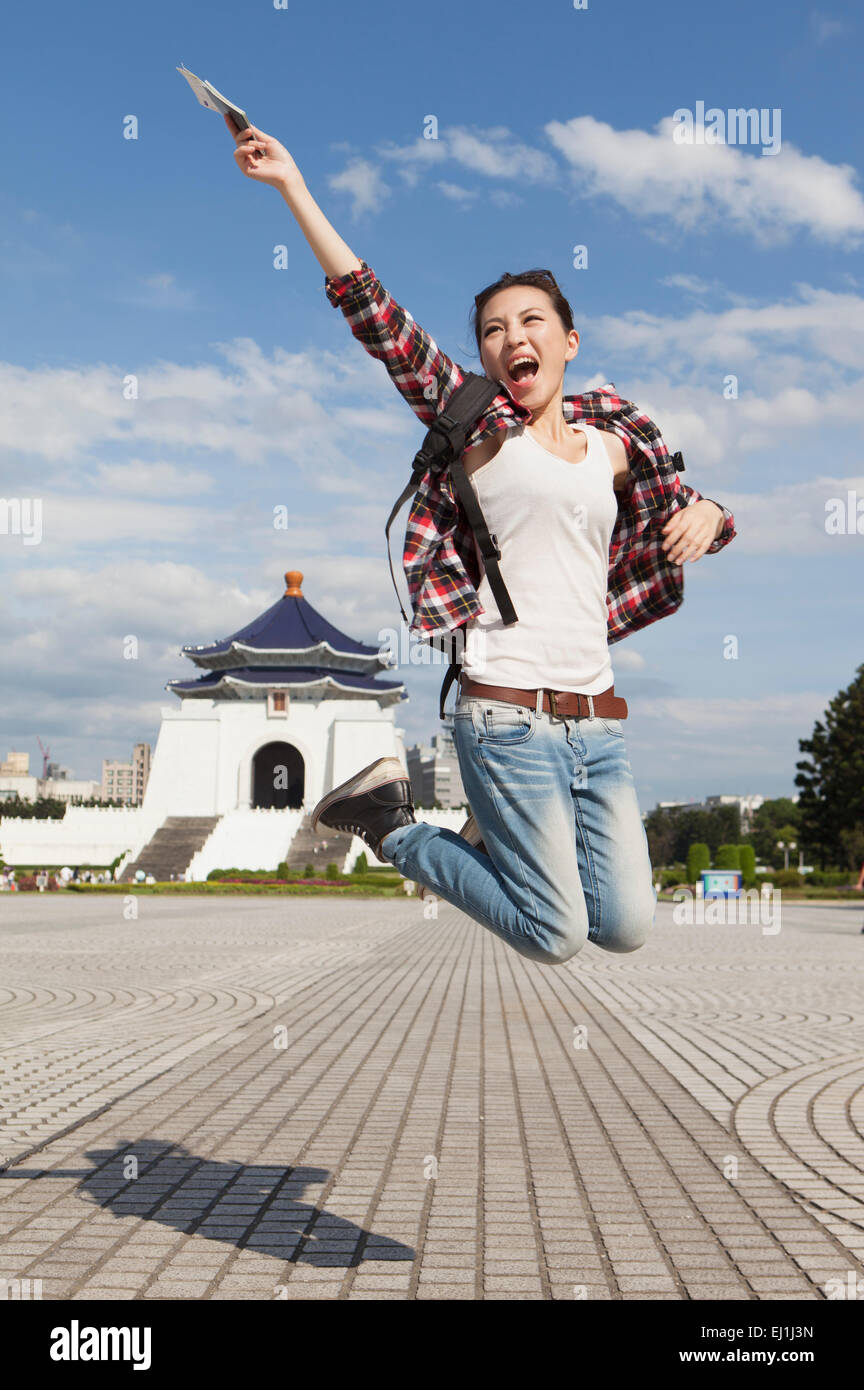 Young woman jumping in mid-air and smiling happily, Stock Photo