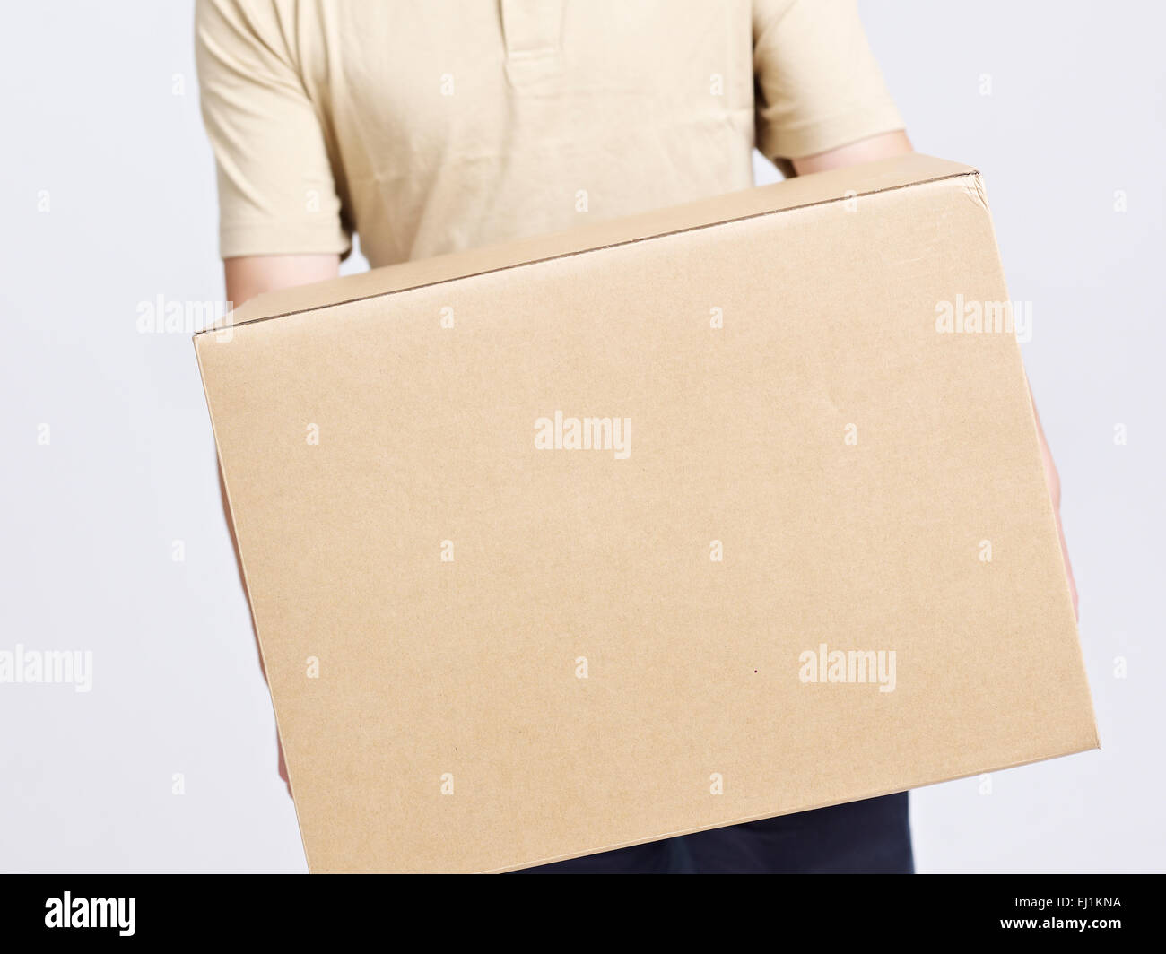 delivery man moving company worker carrying large cardboard box. Stock Photo