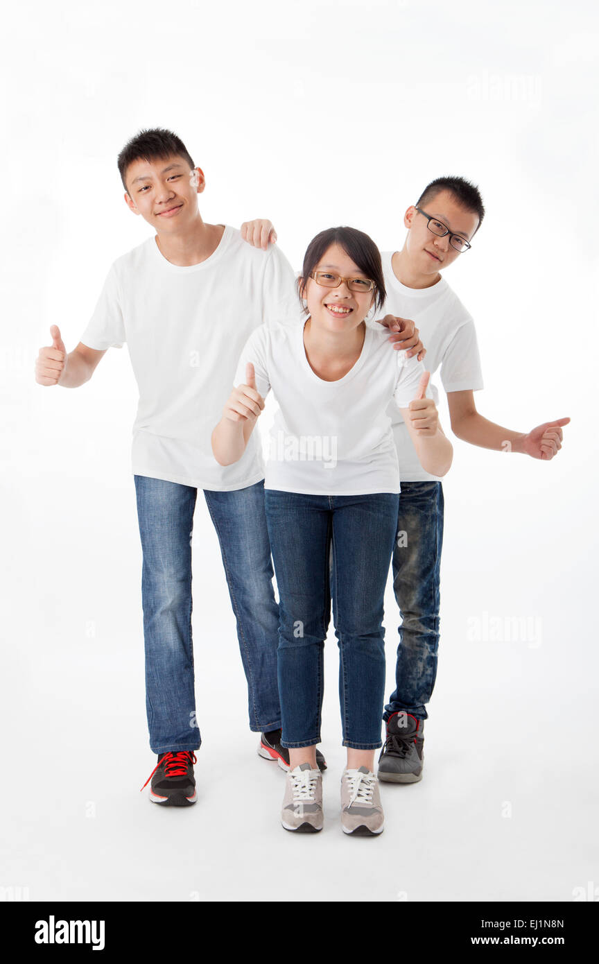 Teenagers smiling at the camera with thumbs up Stock Photo