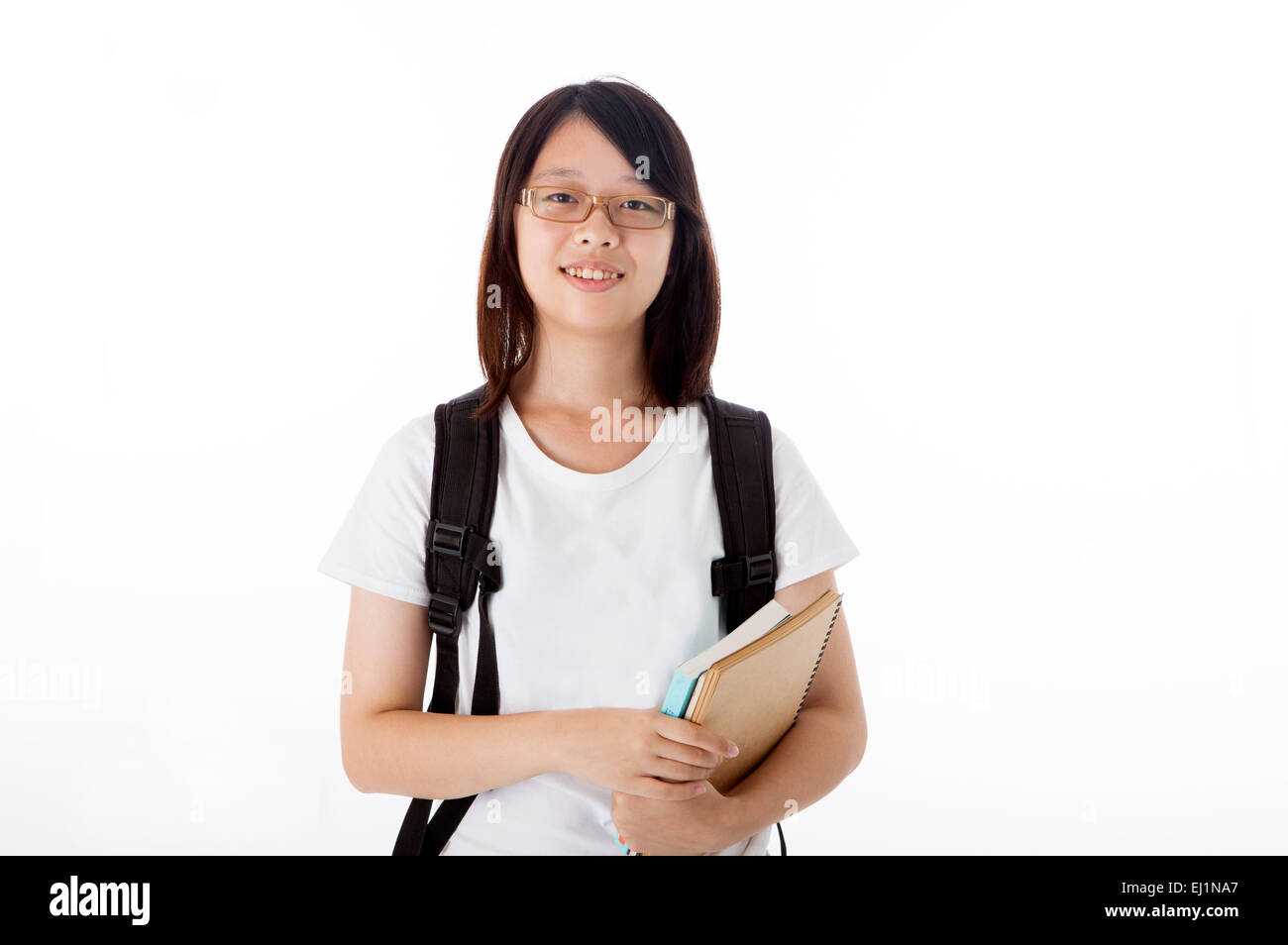 Teenage girl holding books and smiling at the camera Stock Photo - Alamy