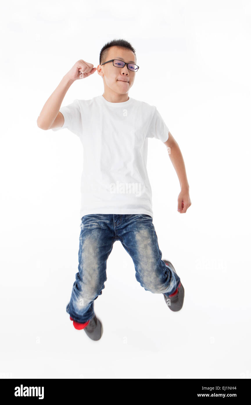 Teenage boy jumping in mid-air with fists up Stock Photo