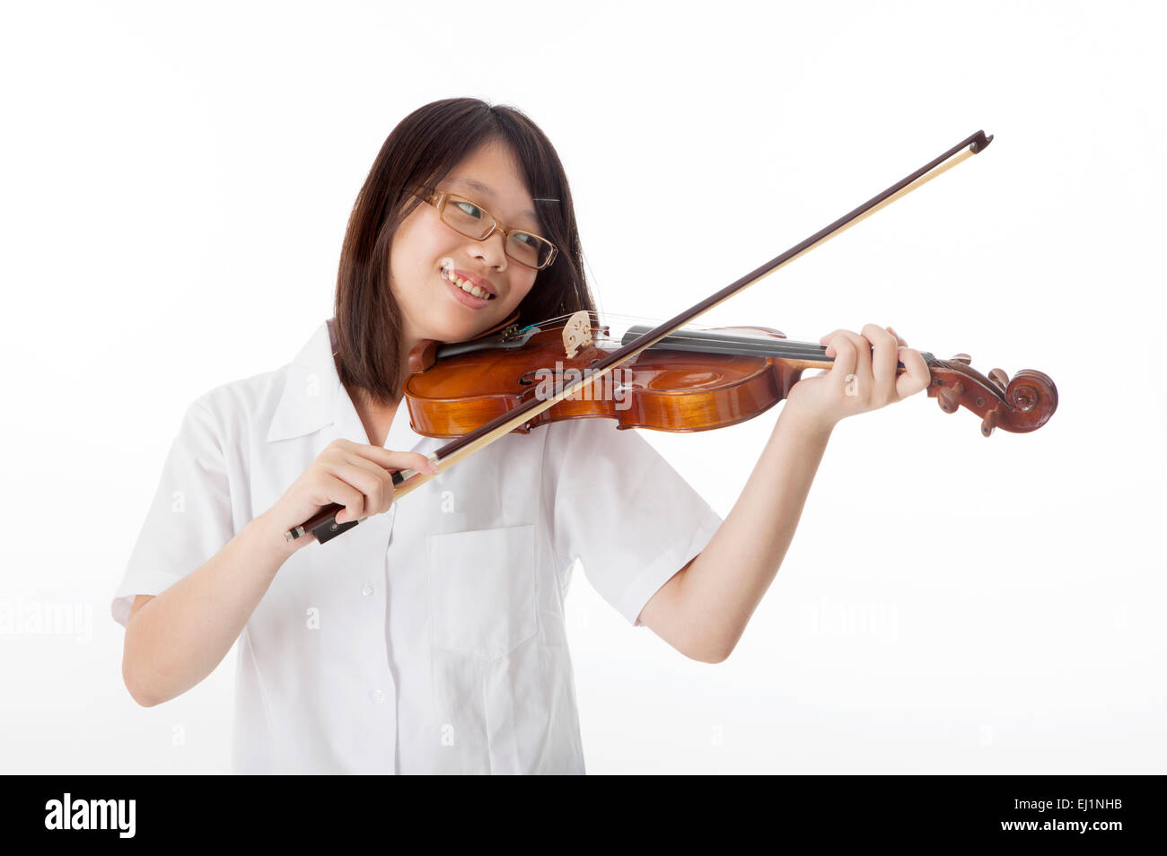 Teenage girl playing violin and looking away with smile Stock Photo - Alamy