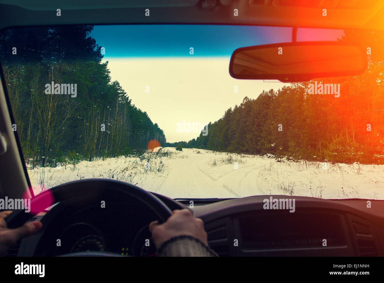 Drive the car on a snowy road in the woods Stock Photo