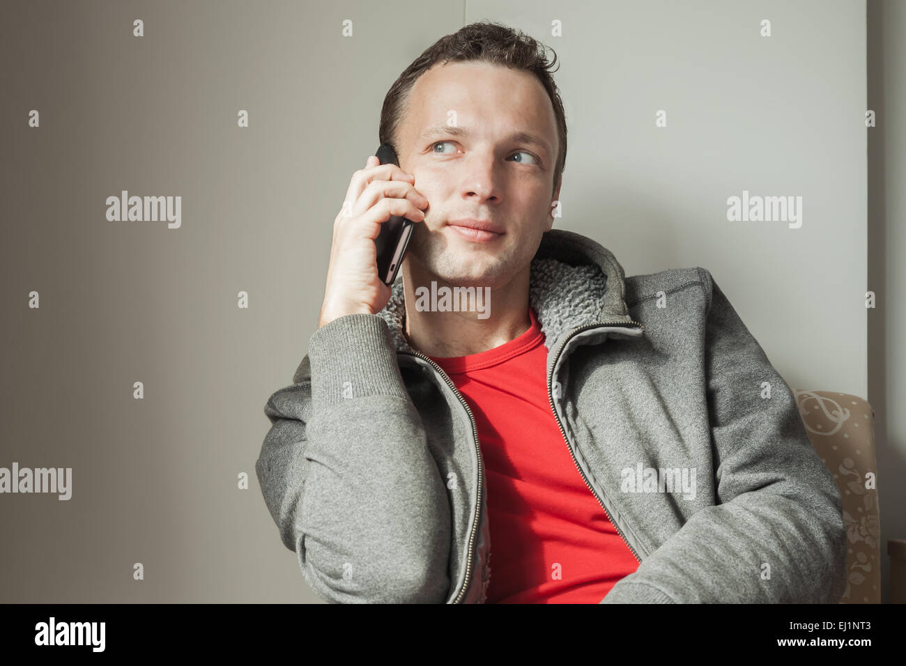 Portrait of young adult Caucasian man talking on mobile phone Stock Photo