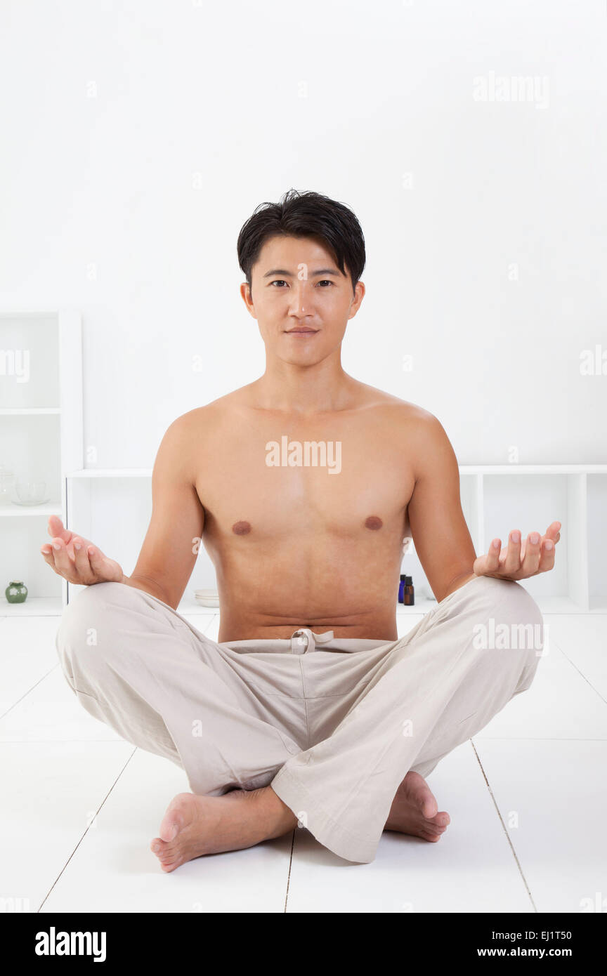 Man sitting and practicing yoga with smile Stock Photo