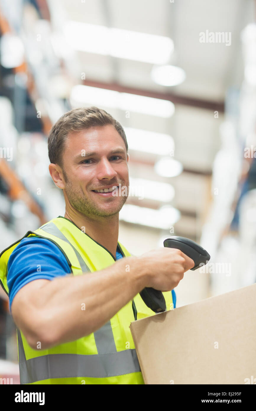 Smiling manual worker scanning package Stock Photo