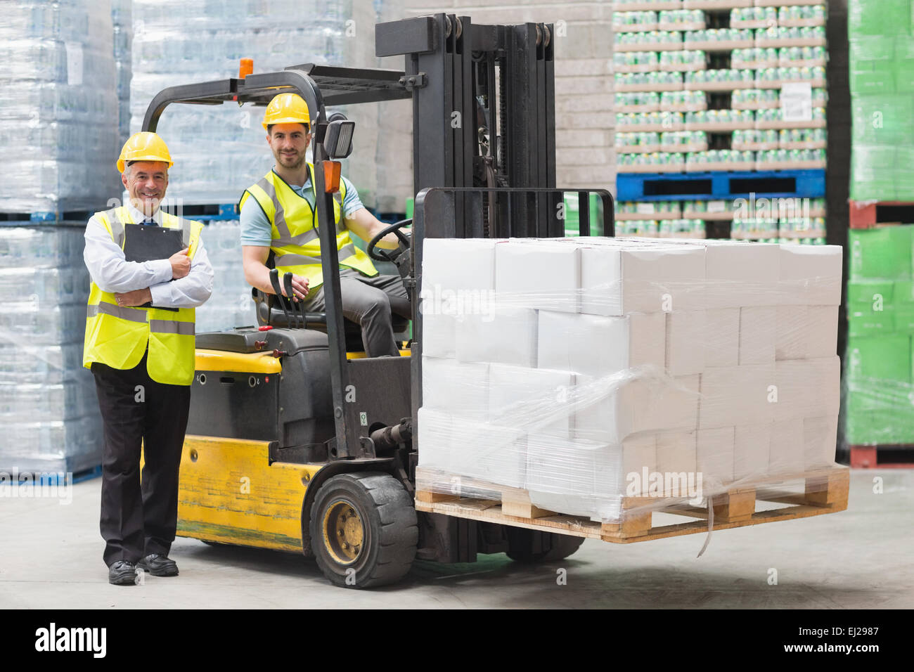 Driver operating forklift machine next to his manager Stock Photo