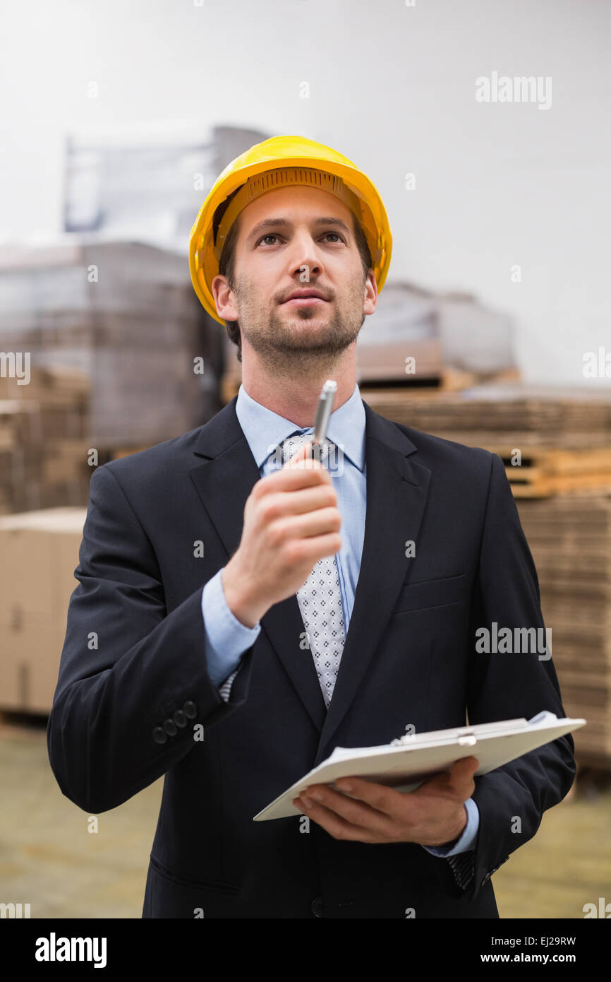 Warehouse manager wearing hard hat checking inventory Stock Photo Alamy