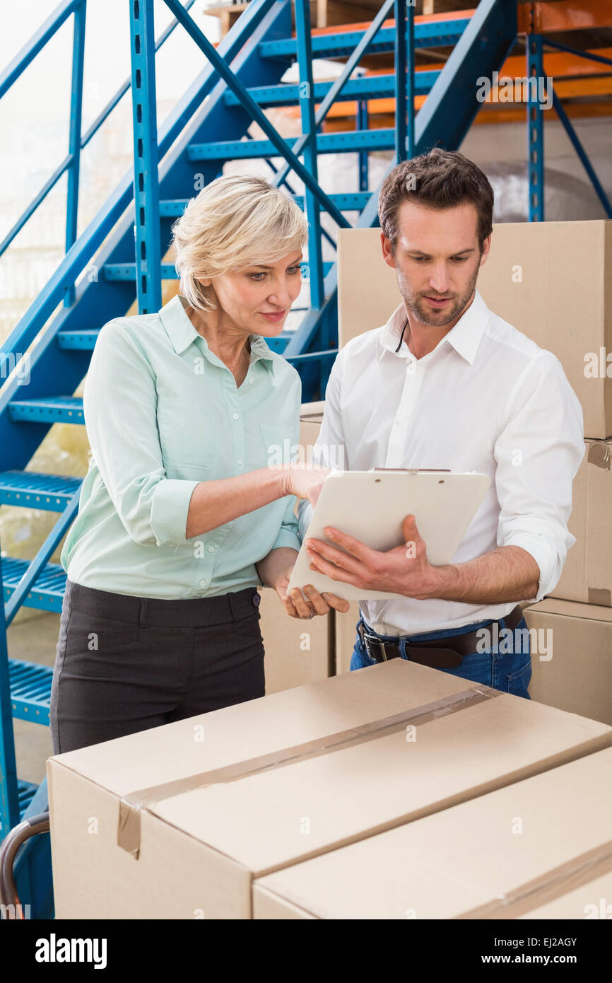 Focused warehouse managers with clipboard Stock Photo - Alamy