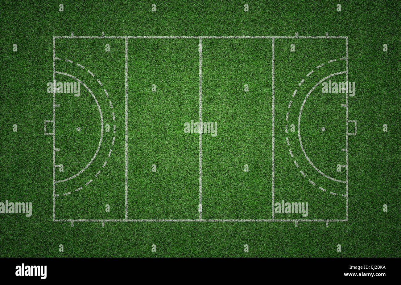 Green grass pitch of field hockey with white lines marking the pitch