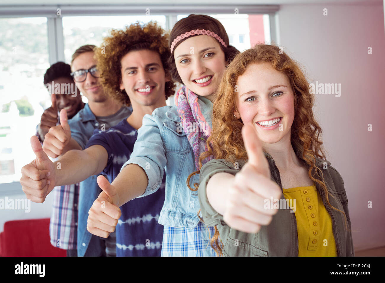 Students smiling in a single line with thumbs up Stock Photo - Alamy