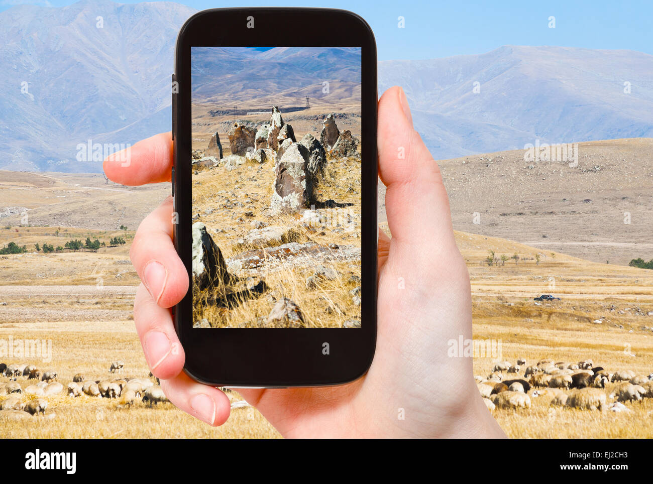 travel concept - tourist takes picture of standing menhirs of Zorats Karer (Carahunge) - pre-history megalithic monument in Arme Stock Photo