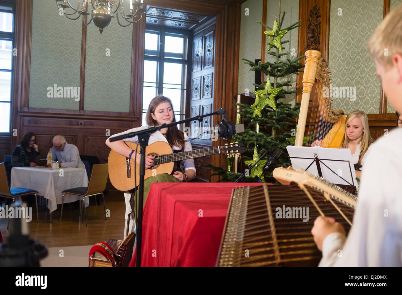 Musicians in regional costumes playing at a cafe at the Adventmarkt in Palais Niederösterreich Vienna, Austria Stock Photo