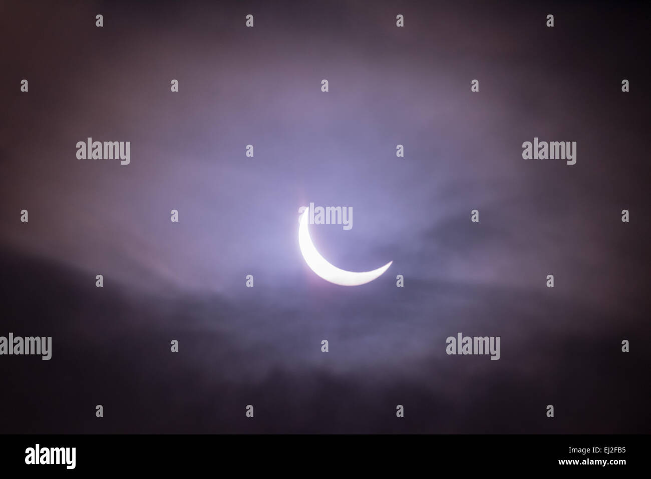 Grafton Underwood, Northamptonshire, UK. 20th March, 2015. The height of the solar eclipse  seen from Grafton Underwood, Nothamptonshire, England, on the morning of 20 march 2015 as clouds  break apart to reveal a crescent shape of the sun. Credit:  miscellany/Alamy Live News Stock Photo