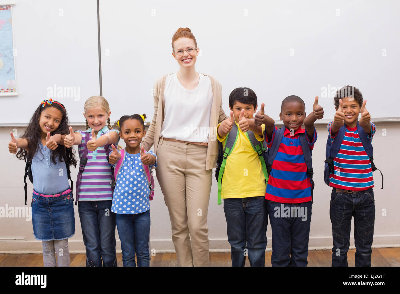 Teacher and pupils smiling at camera in classroom Stock Photo - Alamy