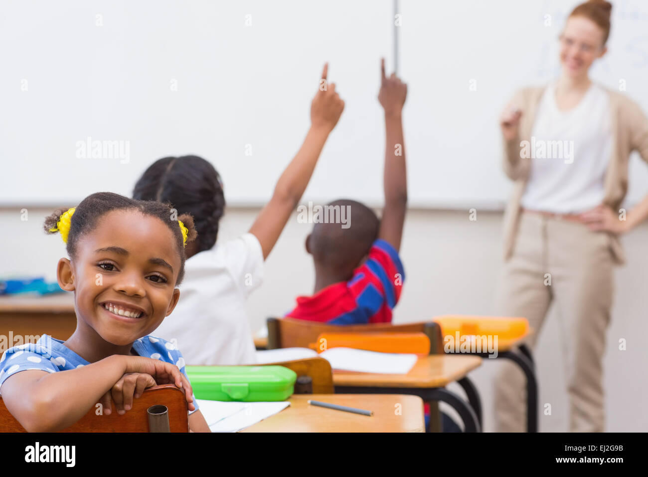 Cute pupil smiling at camera in classroom Stock Photo - Alamy