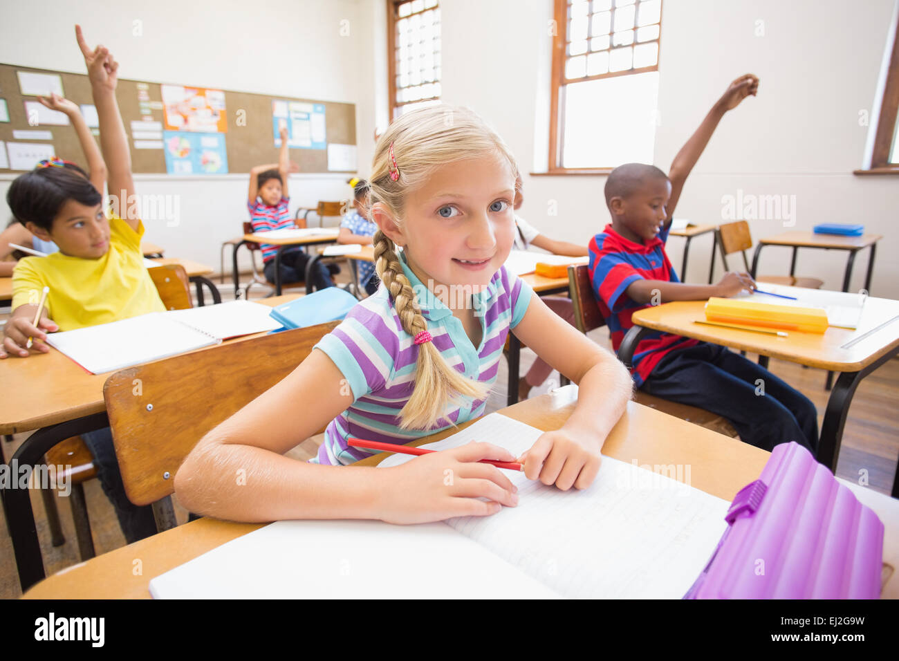 Cute pupil smiling at camera at her desk in classroom Stock Photo - Alamy