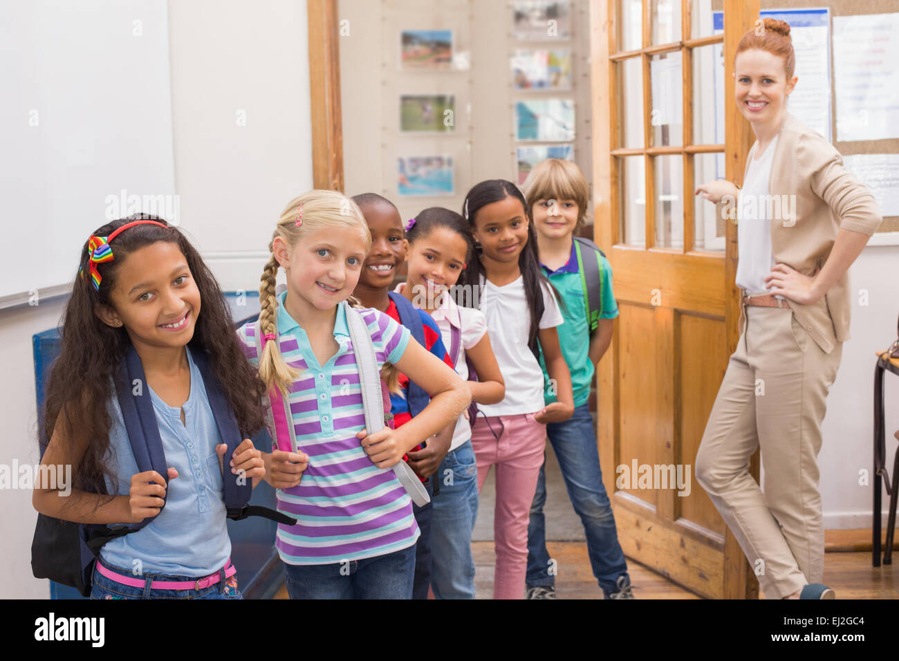 Cute pupils smiling at camera in classroom Stock Photo - Alamy