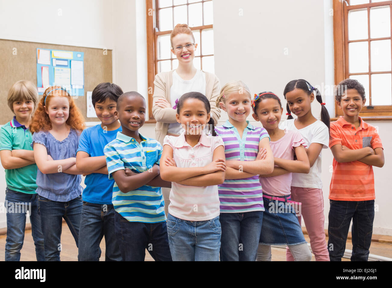 Teacher and pupils smiling at camera in classroom Stock Photo - Alamy