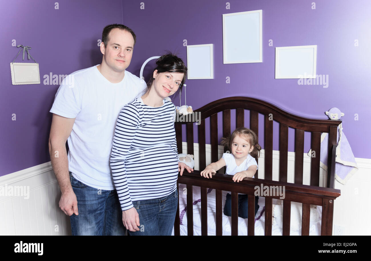 family inside the baby's room with baby in crib. Stock Photo