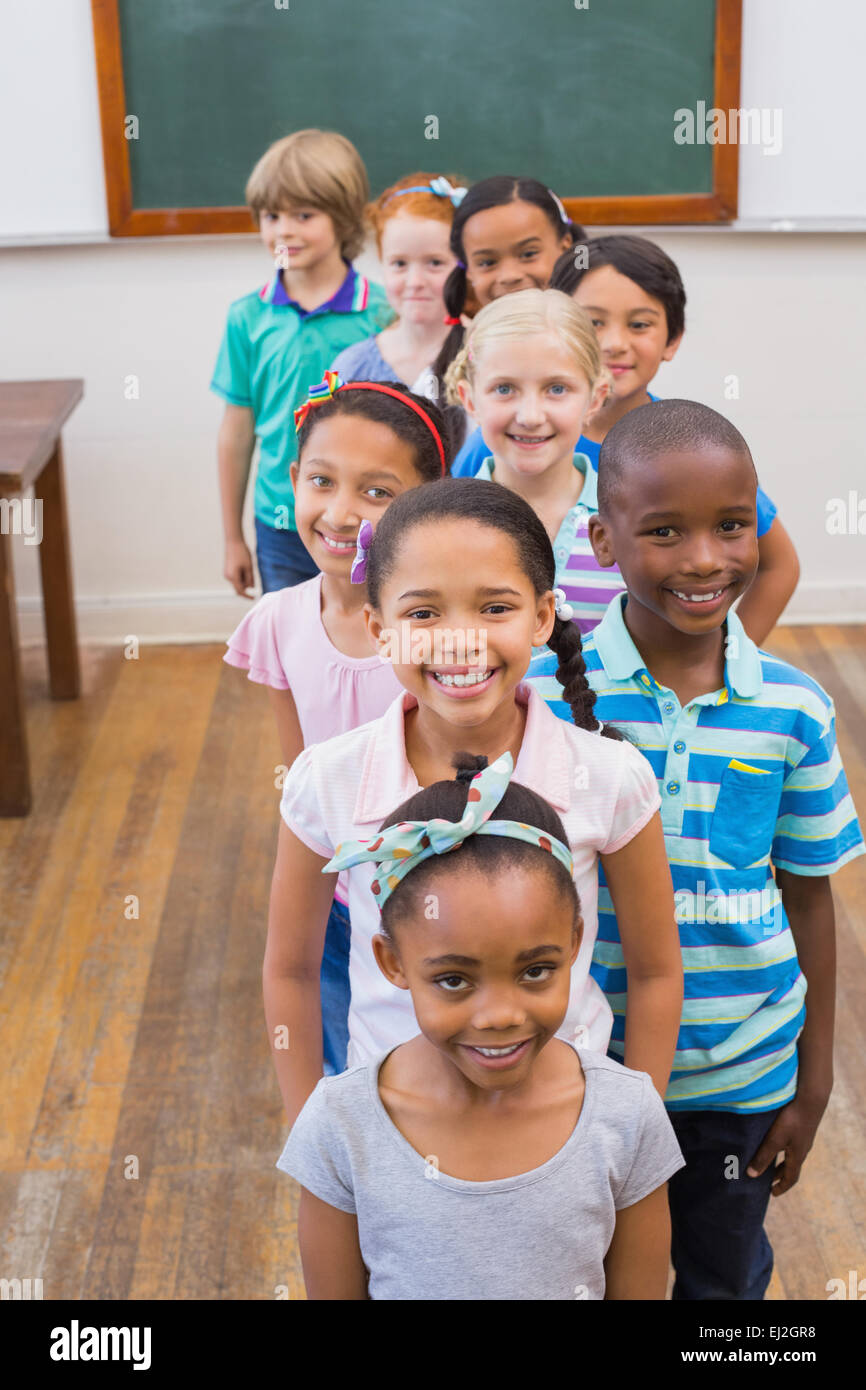 Cute pupils smiling at camera in classroom Stock Photo - Alamy