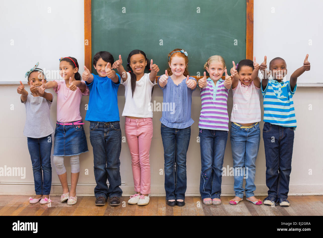 Cute pupils smiling at camera in classroom Stock Photo - Alamy