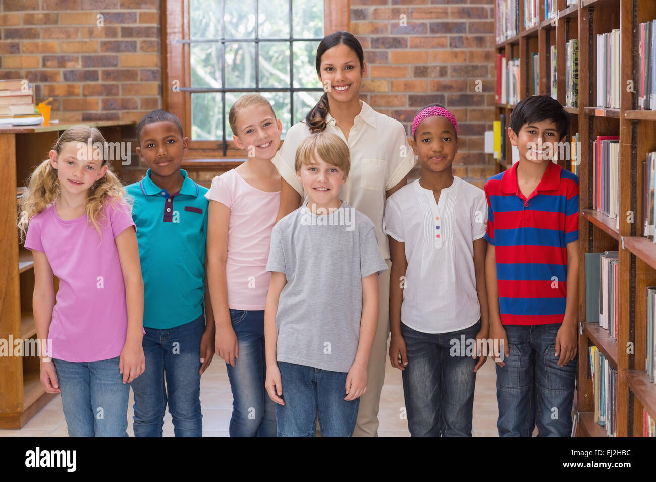 Cute pupils smiling at camera in classroom Stock Photo - Alamy
