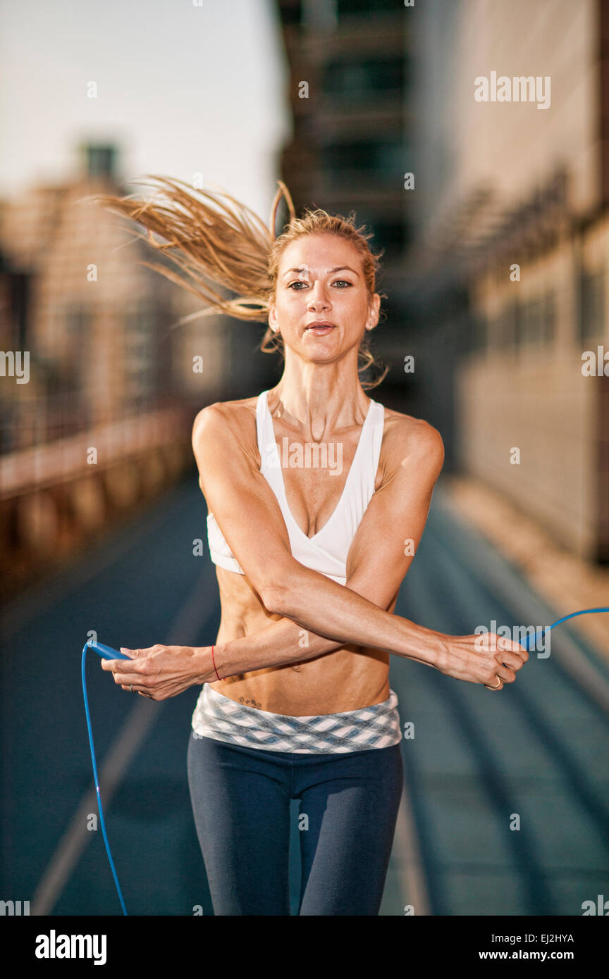 Pretty blond fit women jumping rope outdoors Stock Photo - Alamy