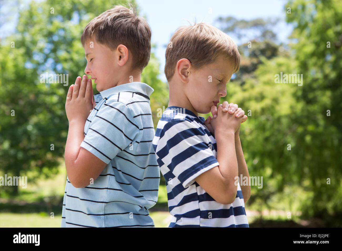 Little boys praying in the park Stock Photo - Alamy