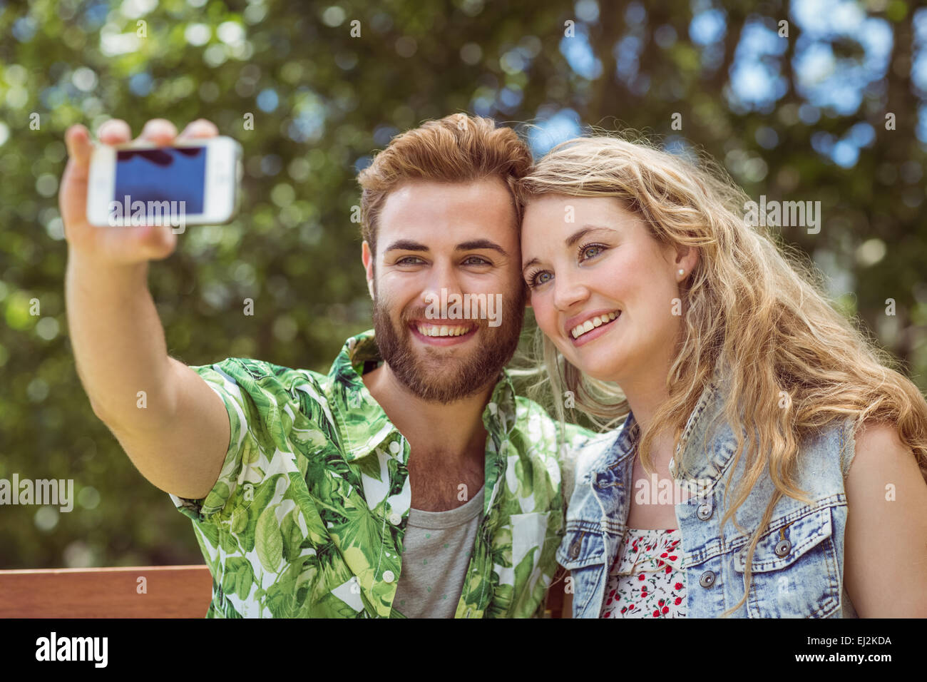 Young couple relaxing on park bench Stock Photo - Alamy