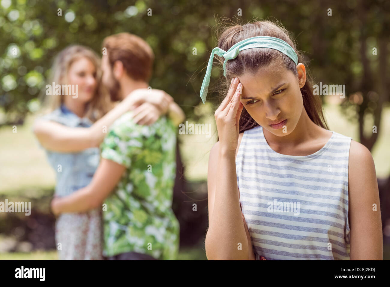 Brunette upset at seeing boyfriend with other girl Stock Photo