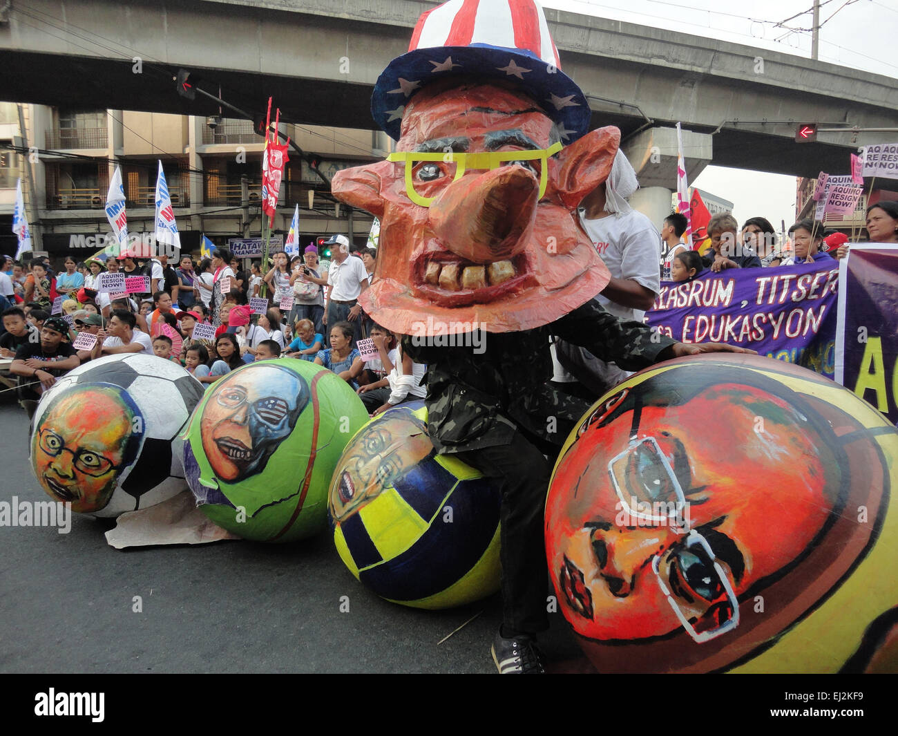 Manila, Philippines. 20th Mar, 2015. A Filipino activist wearing a mask depicting Philippine President Benigno Aquino III as 'Pinocchio' donning a US-styled top hat looks on alongside balls containing the faces of the Philippine president, during a rally at Mendiola. President Aquino is facing calls for his removal over the botched anti-terror operation last January 25 in Mamasapano, Maguindanao to hunt wanted Malaysian bombmaker Zulkifri bin Hir, alias Marwan, that resulted in the deaths of 44 police commandos. Credit:  Richard James Mendoza/Pacific Press/Alamy Live News Stock Photo