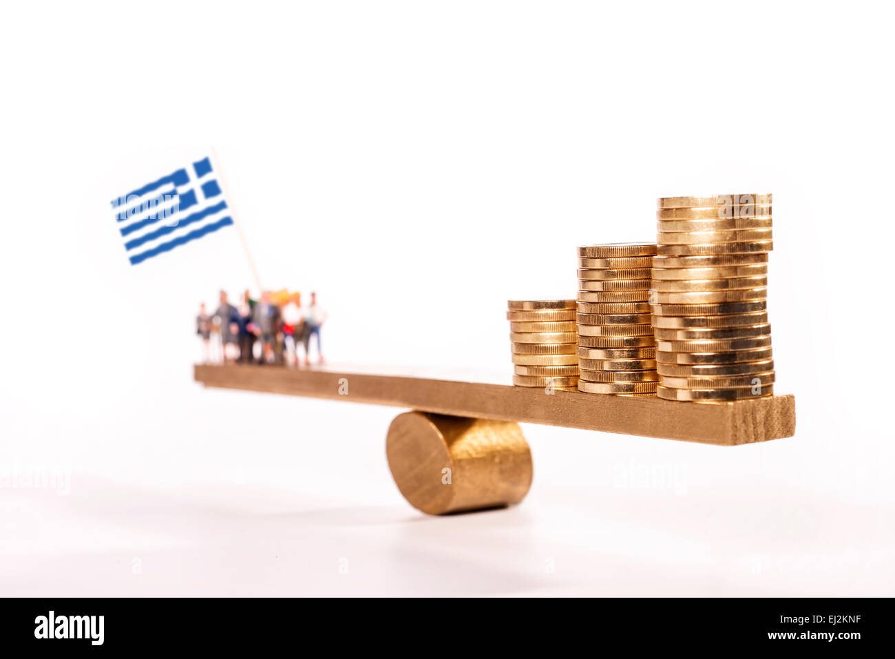 Seesaw with coins on one side and a group of people with the Greek flag on the other side. Stock Photo