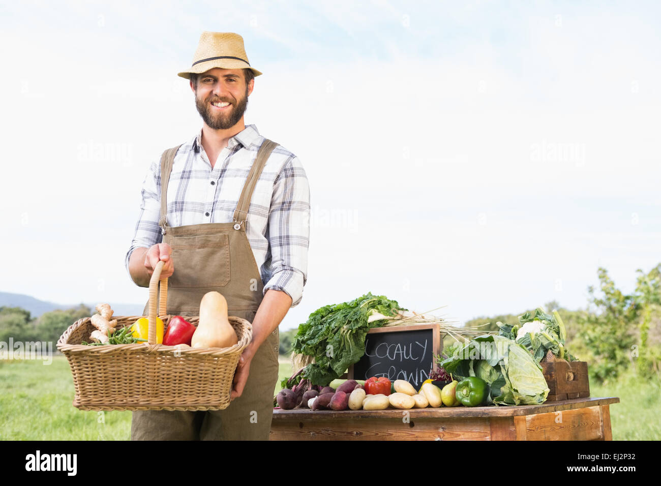 Farmer holding basket of vegetables at market Stock Photo - Alamy