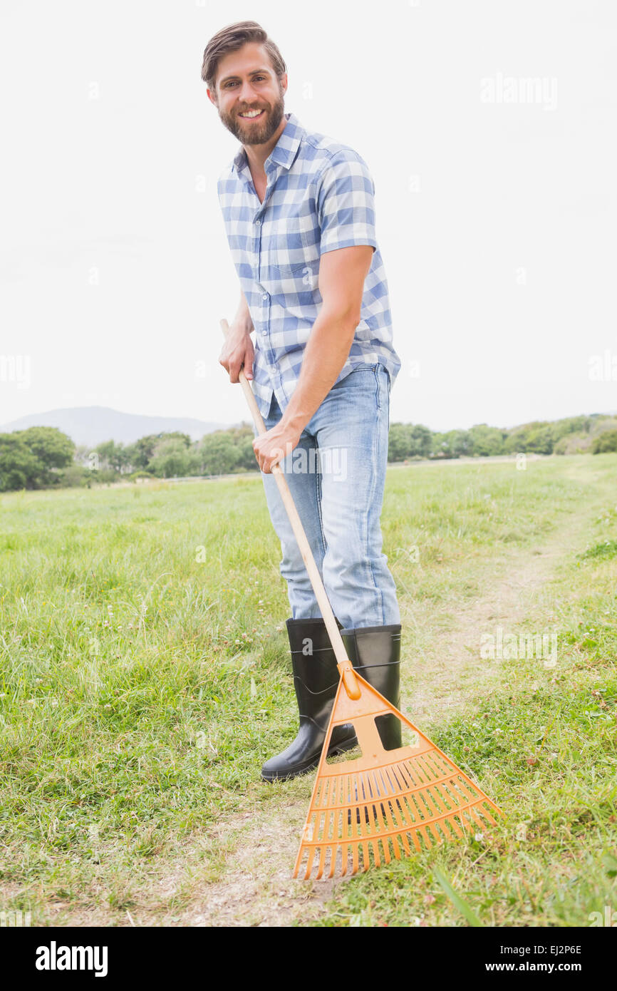 Happy man raking his farm Stock Photo