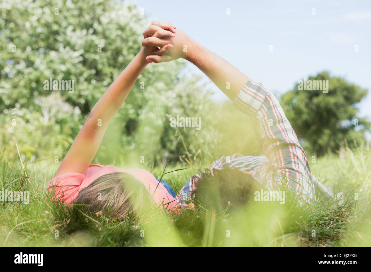 Cute couple holding hands in the park Stock Photo - Alamy