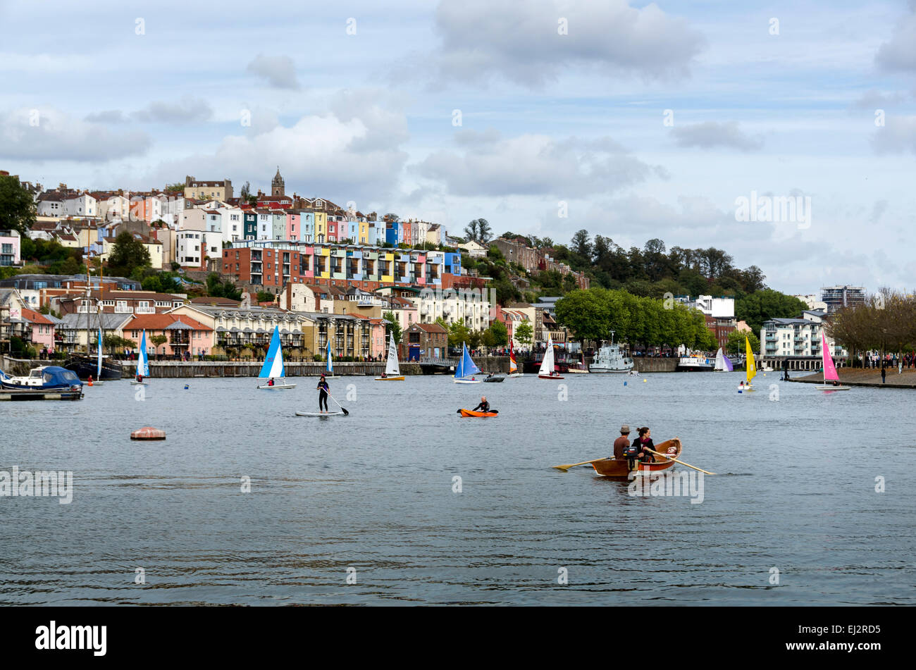 Activity on Bristol's Floating Harbour, a variety of small boats watched over by the attractive coloured houses of Cliftonwood. Stock Photo