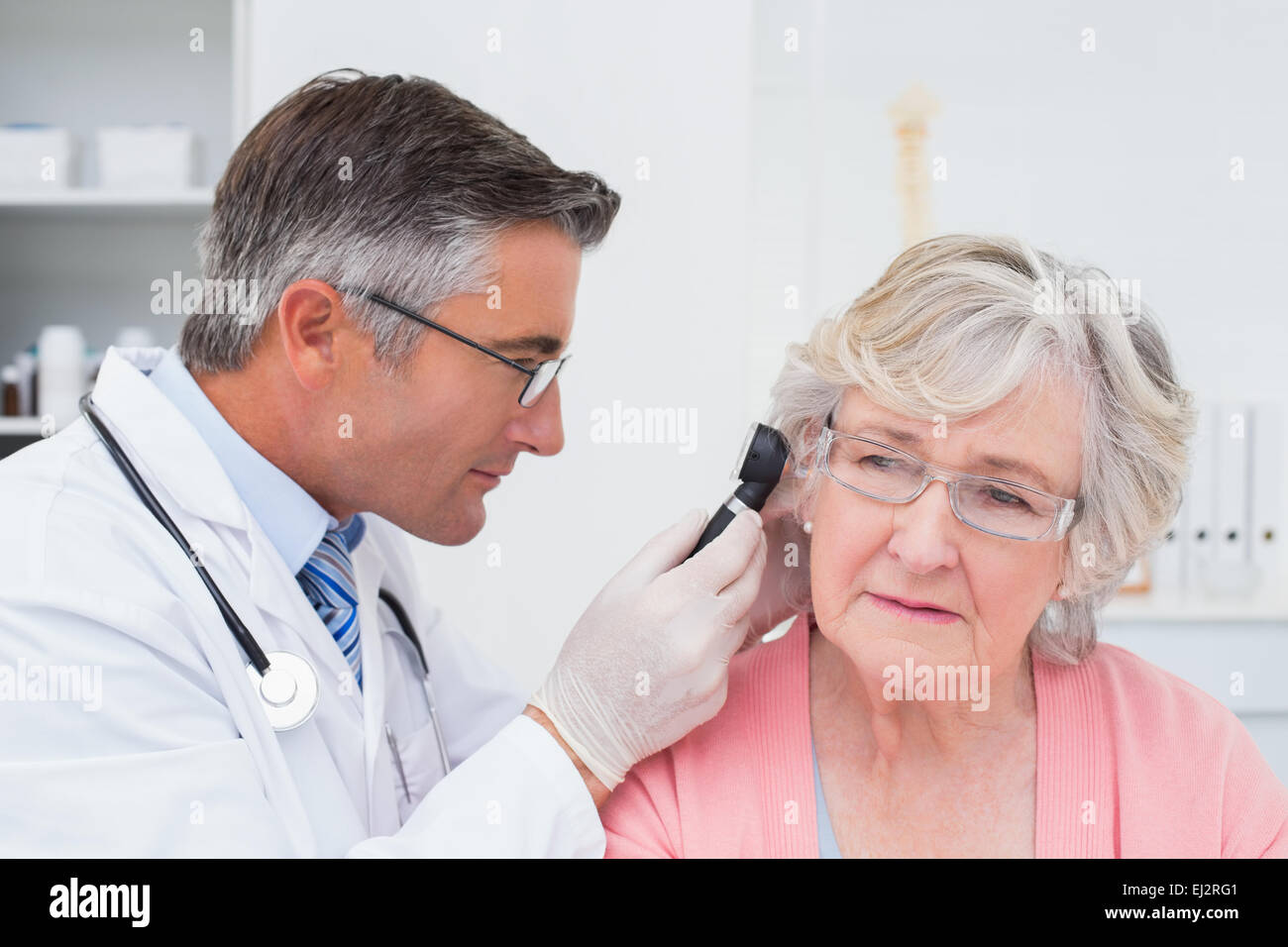 Doctor examining female patients ear with otoscope Stock Photo Alamy