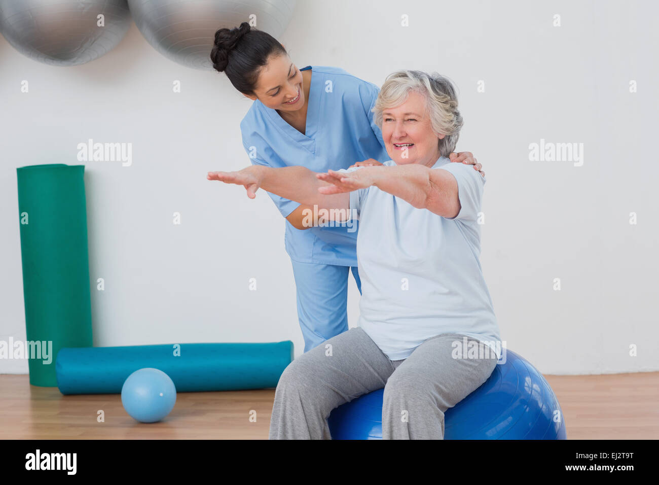 Senior Instructor Instructor assisting senior woman in exercising Stock Photo - Alamy