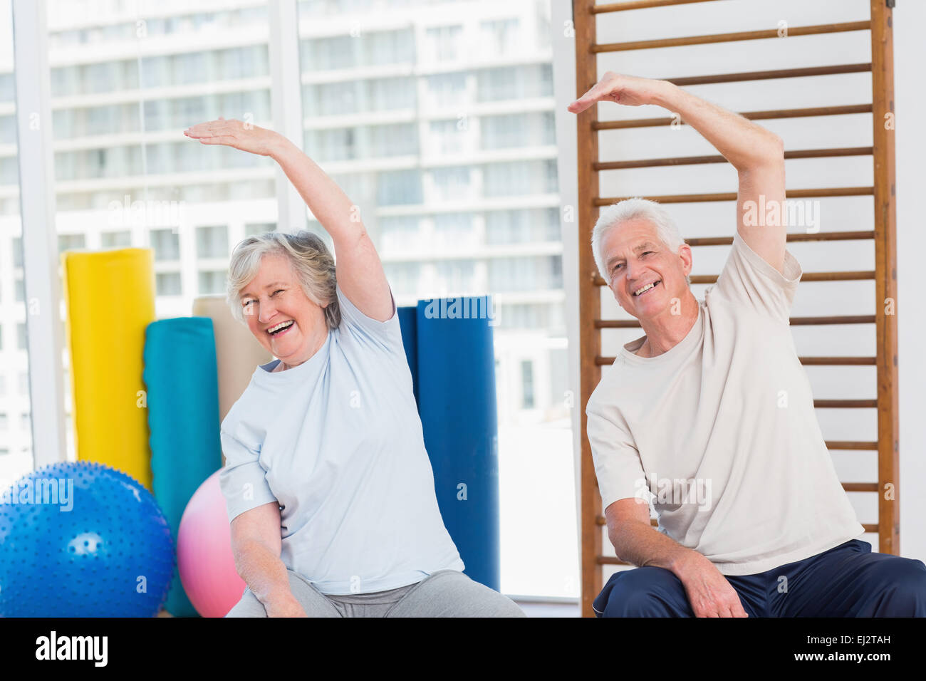 Senior couple doing stretching exercise in gym Stock Photo - Alamy