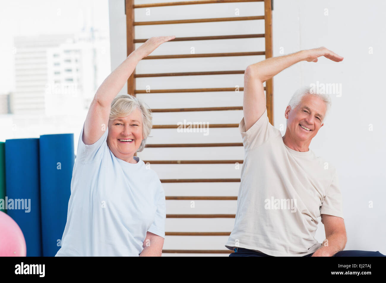 Senior couple doing stretching exercise in fitness studio Stock Photo ...