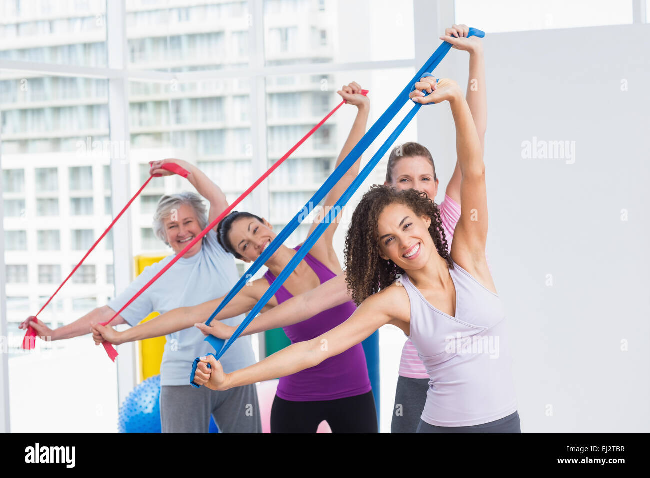 Happy female friends exercising with resistance bands Stock Photo