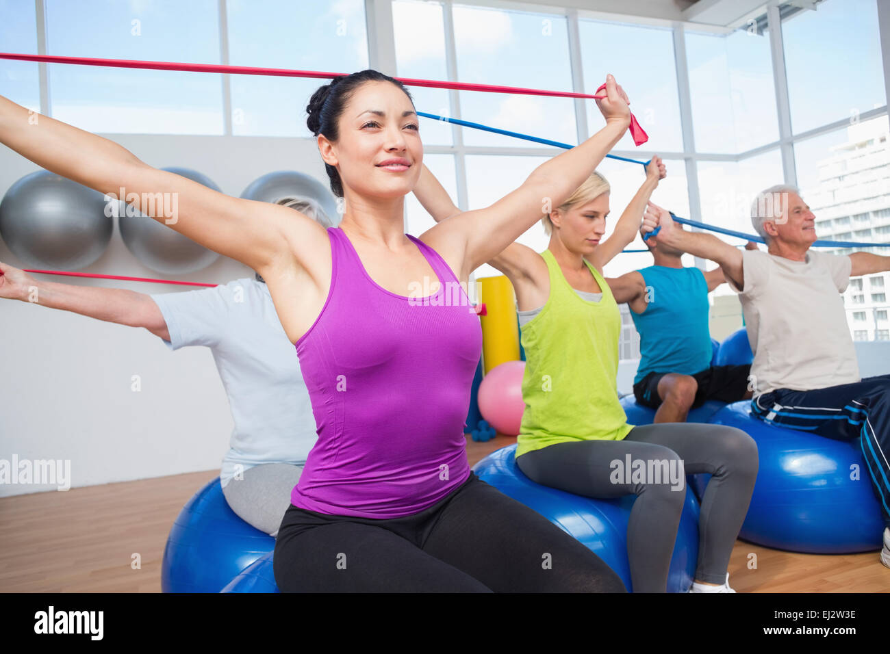 People exercising with resistance bands in gym Stock Photo