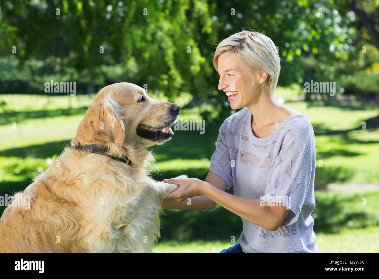 Pretty blonde playing with her dog in the park Stock Photo - Alamy