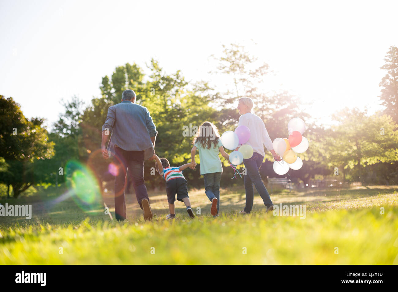 Happy family walking at the park Stock Photo - Alamy
