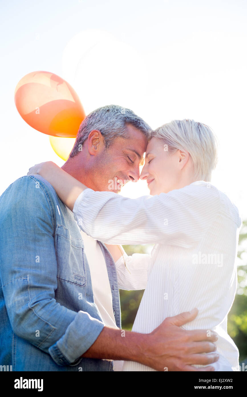 Cute couple holding balloons at the park Stock Photo - Alamy
