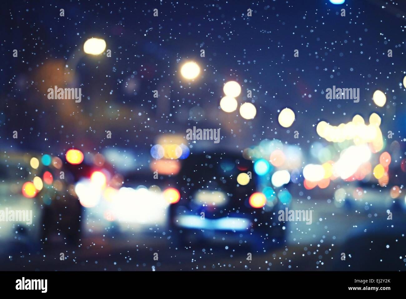 blurred night background city traffic road city lights winter snow glare Stock Photo
